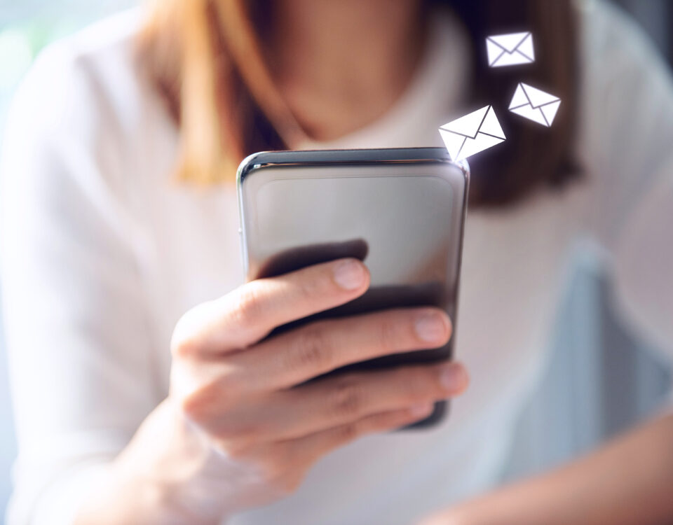 Close up of girl's hand holding smartphone with envelope message icons