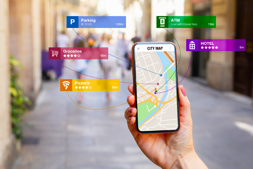Hand holding smartphone in street with travel locations marked on map hotel parking groceries ATM parking pizzeria