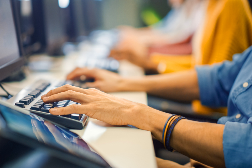 Customer service team hands typing on computers in a row