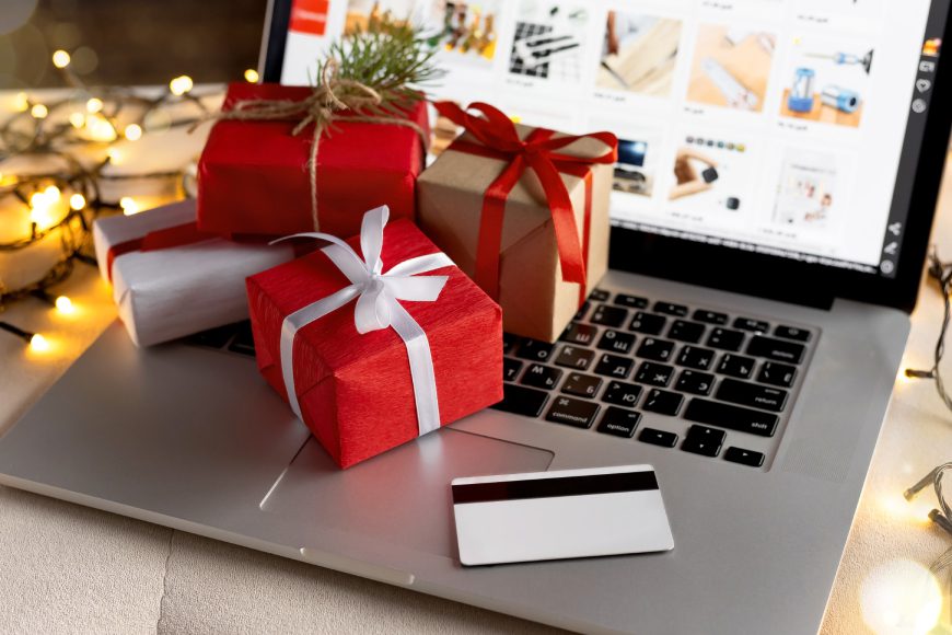 Christmas gifts on laptop keyboard with shopping website on screen