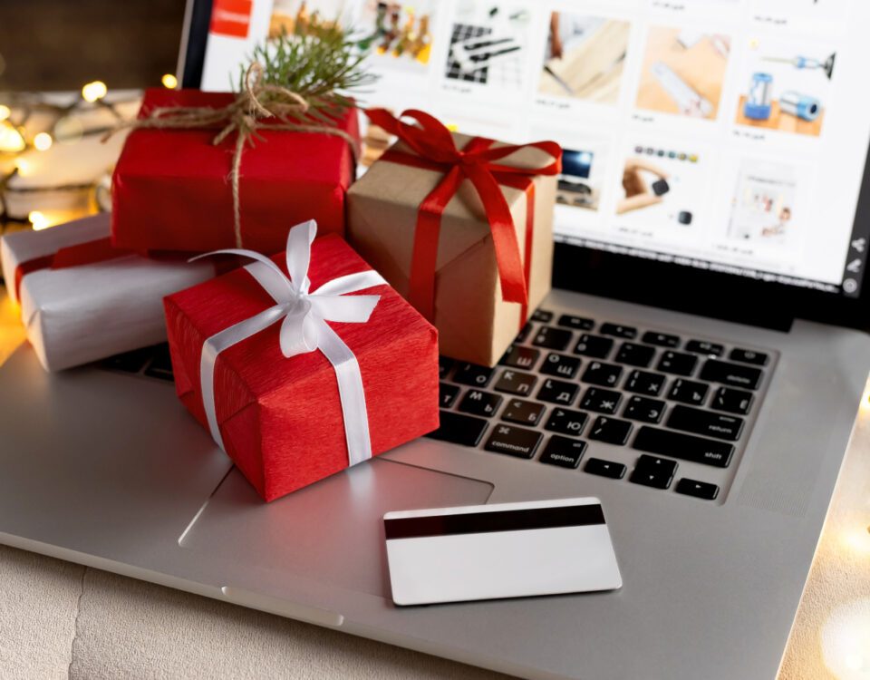 Christmas gifts on laptop keyboard with shopping website on screen