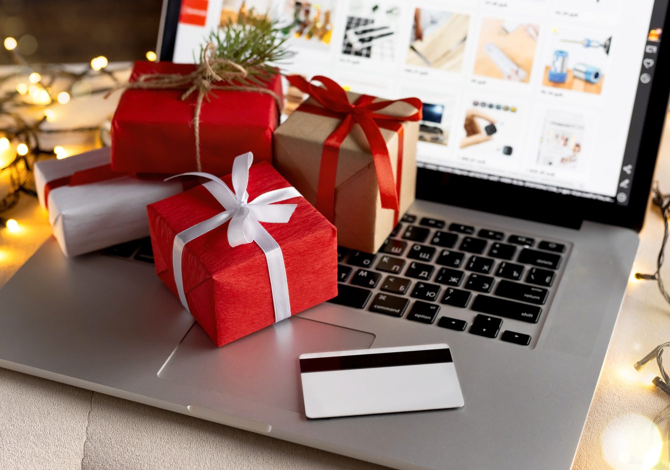 Christmas gifts on laptop keyboard with shopping website on screen