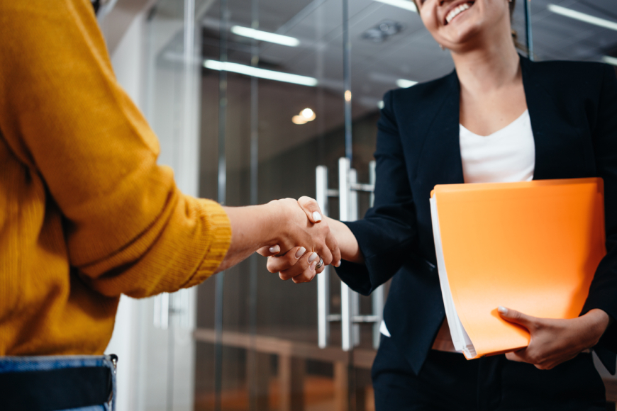 Two women shaking hands in casual office