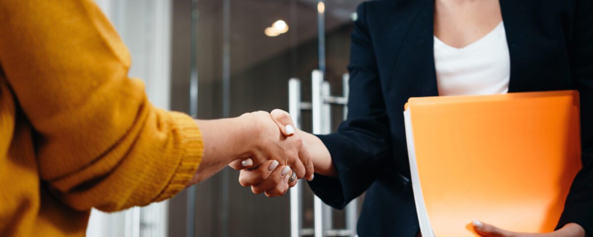 Two women shaking hands in casual office
