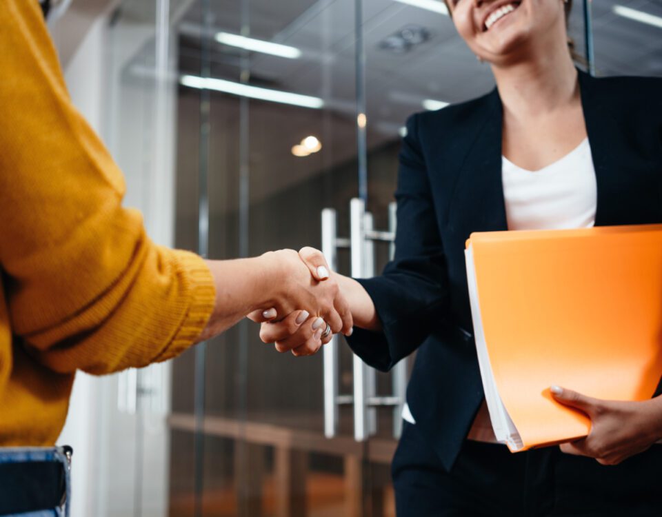 Two women shaking hands in casual office