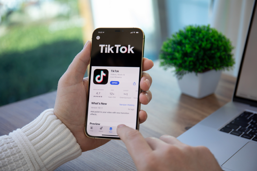 Hands holding smartphone with TikTok on screen