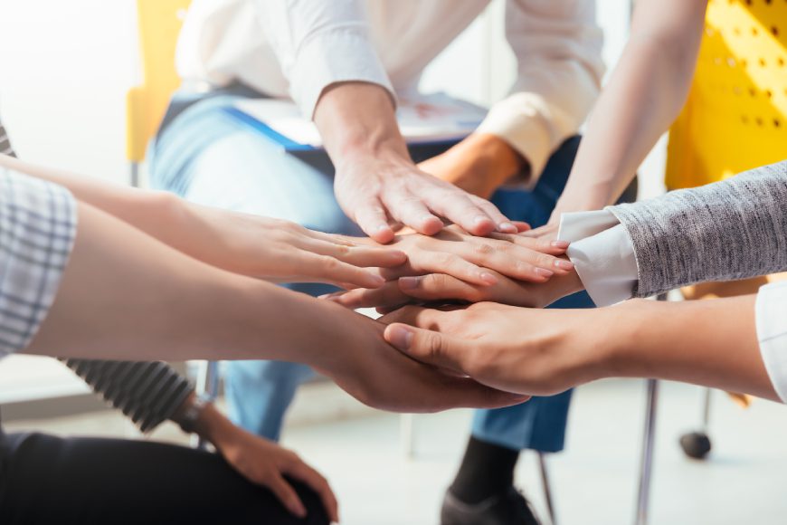 Team members putting their hands together