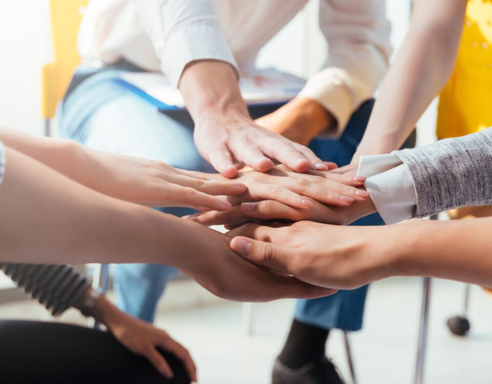 Team members putting their hands together