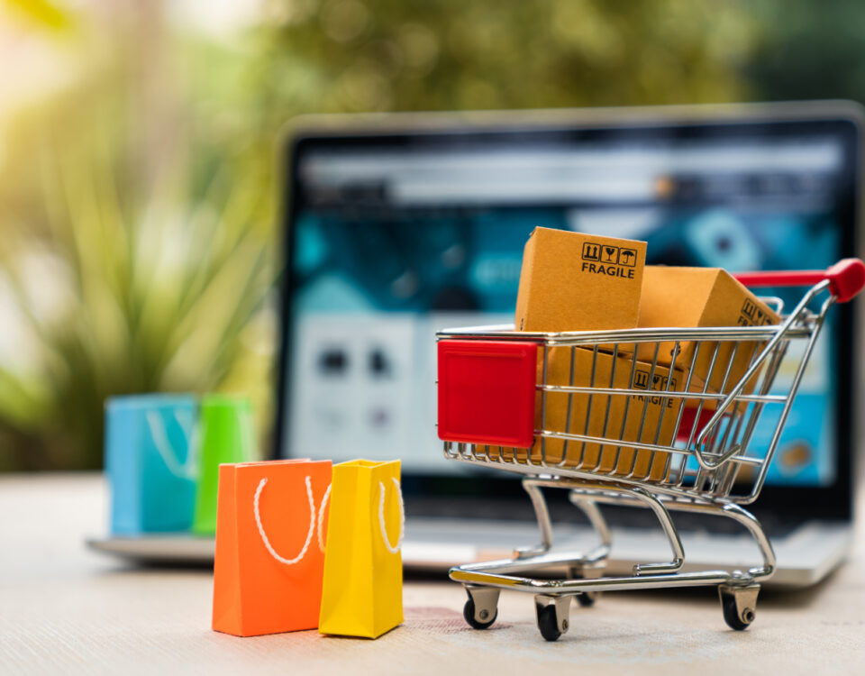 Shopping cart and bags in front of laptop