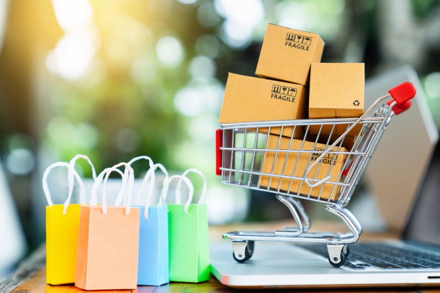 Shopping cart with bags and boxes on laptop