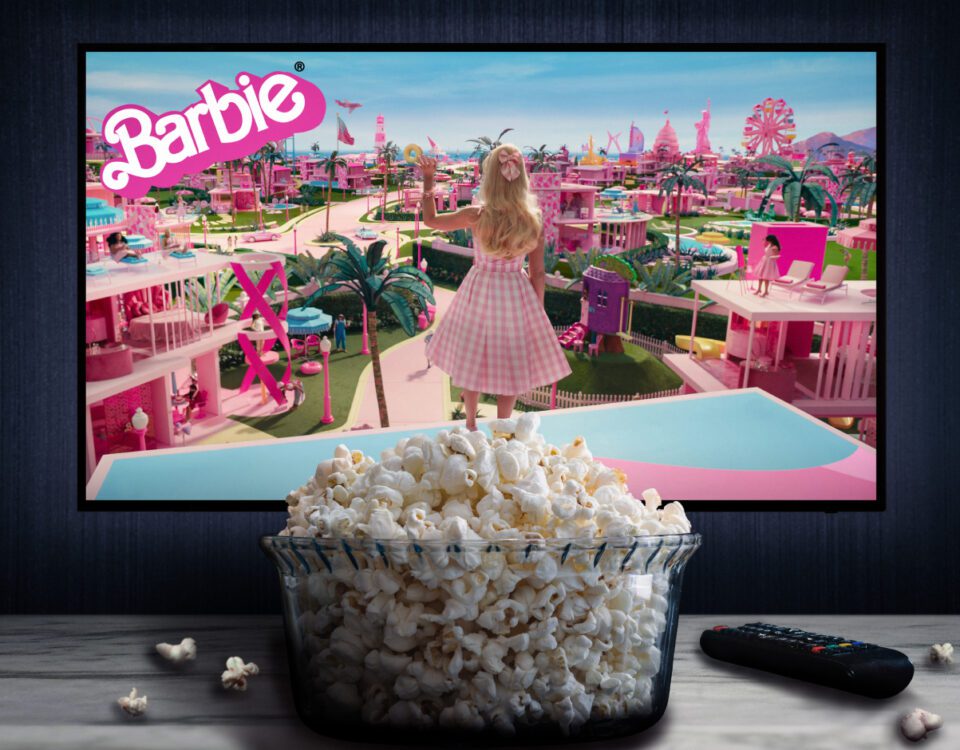 TV with Barbie movie on screen and bucket of popcorn in foreground