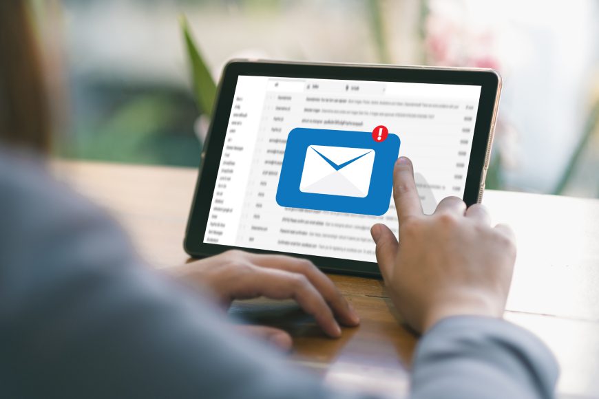 Person sitting at desk tapping on iPad tablet screen with incoming message notification