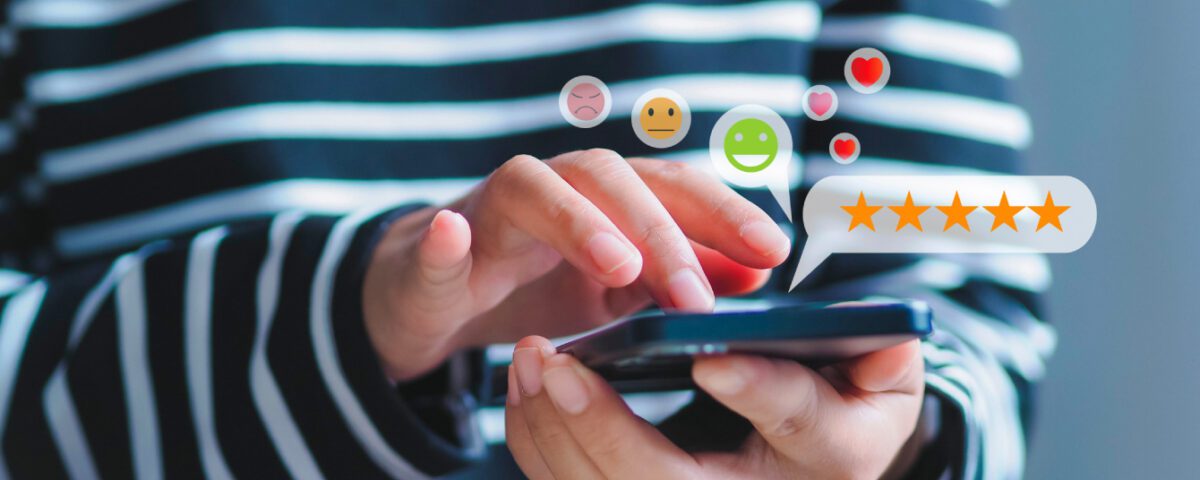 Hands holding smartphone with customer satisfaction survey rating icons