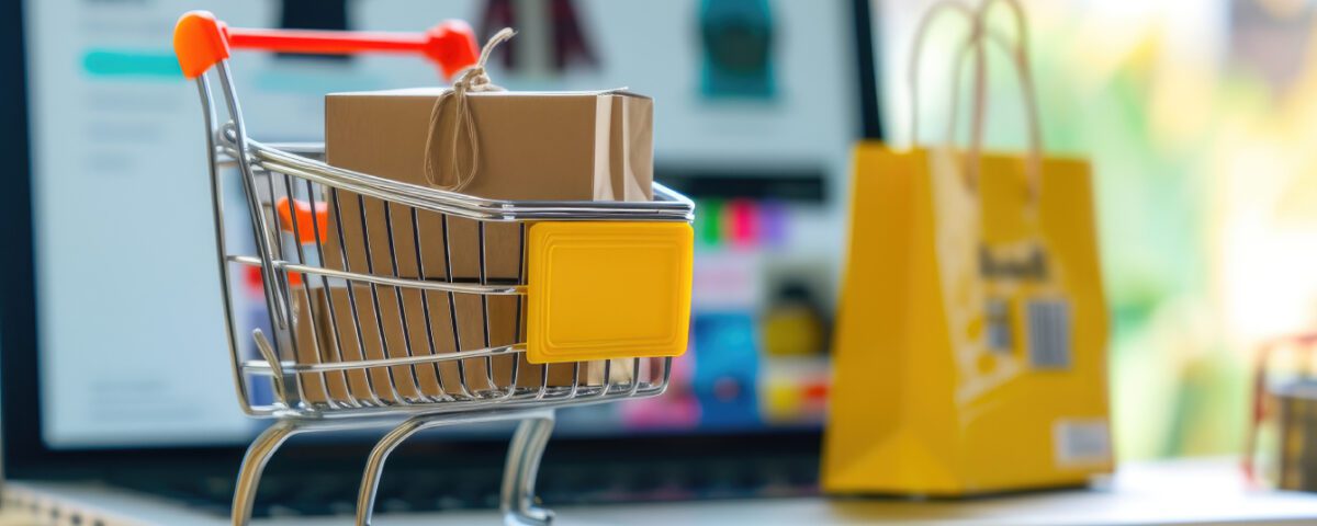 Miniature shopping cart and bags on laptop keyboard