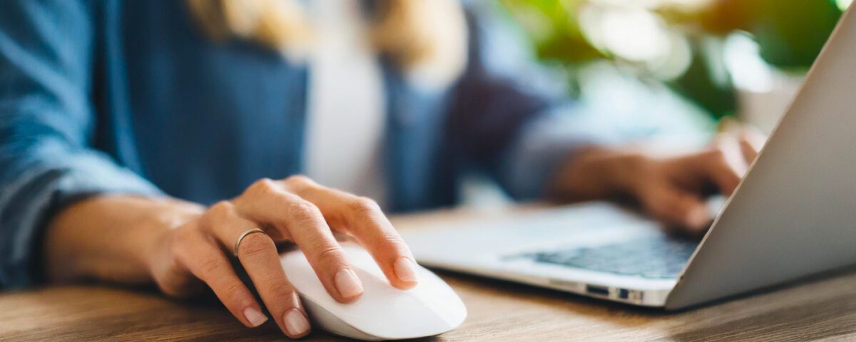 Woman using laptop with mouse on desk