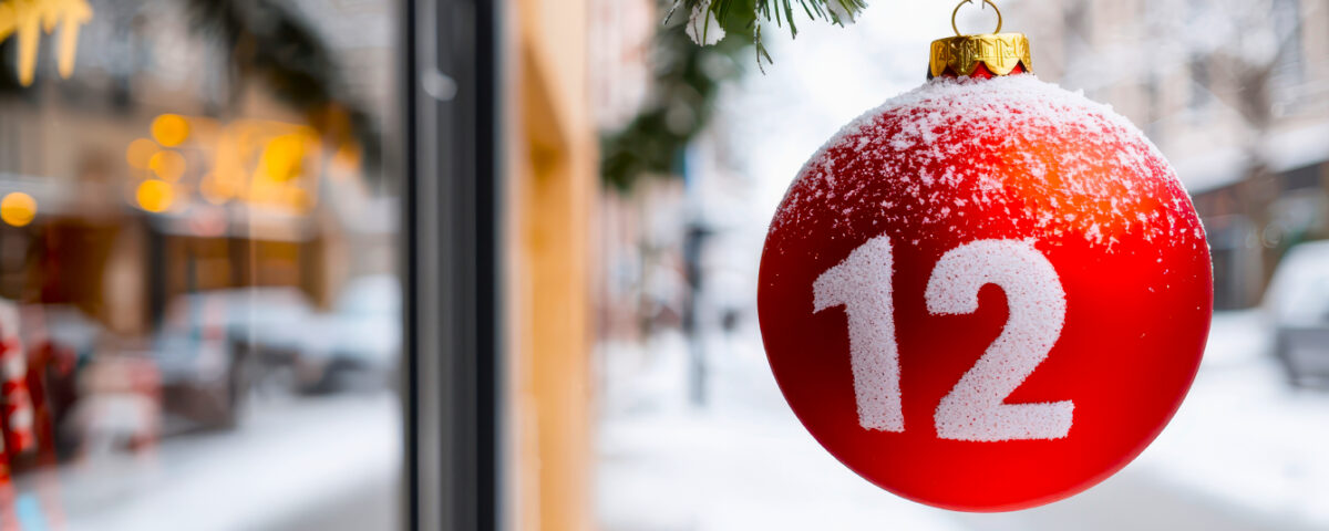 Red bauble Christmas decoration ornament with number 12 hanging outside a store