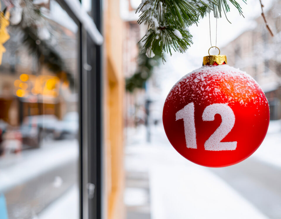 Red bauble Christmas decoration ornament with number 12 hanging outside a store