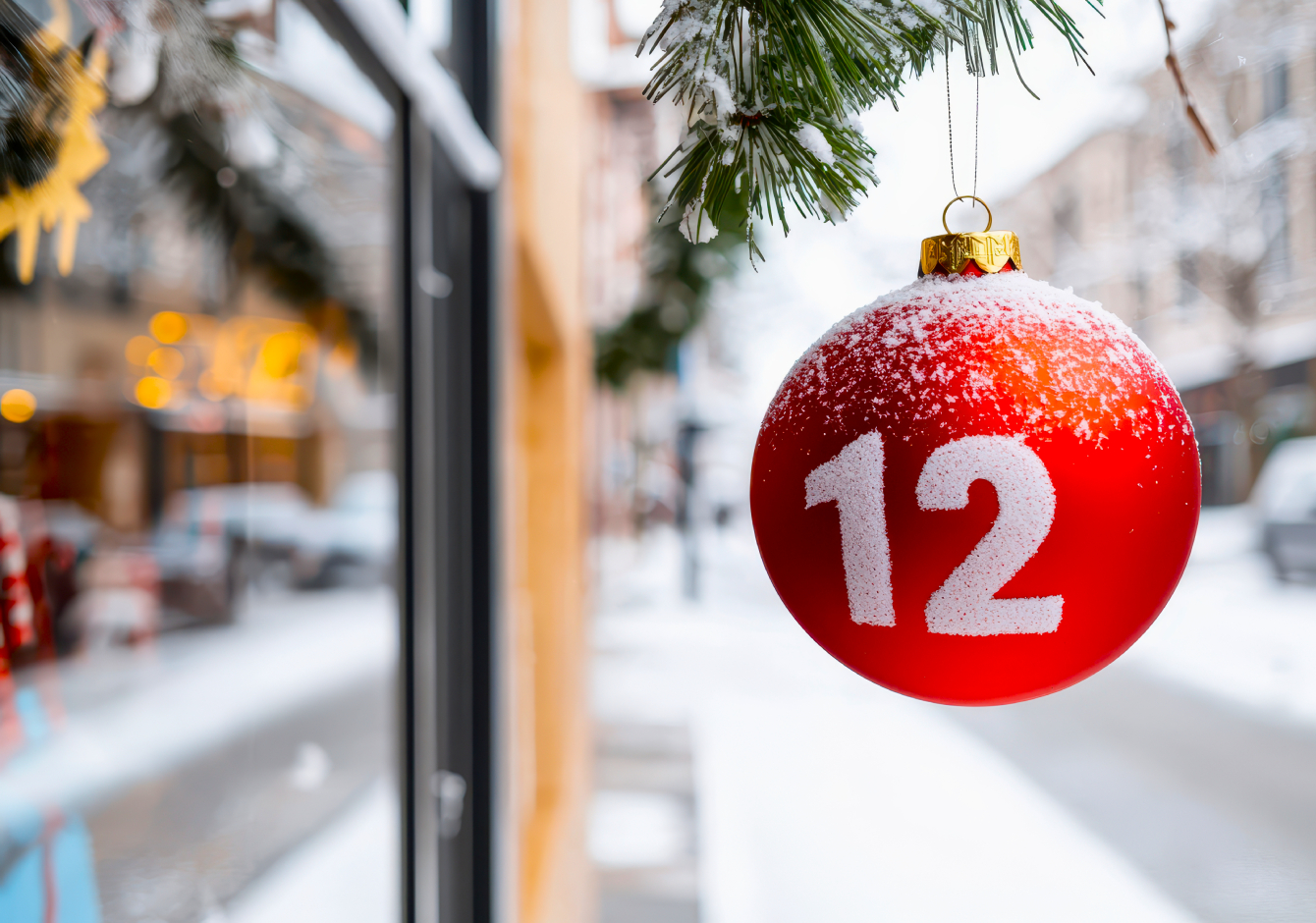 Red bauble Christmas decoration ornament with number 12 hanging outside a store