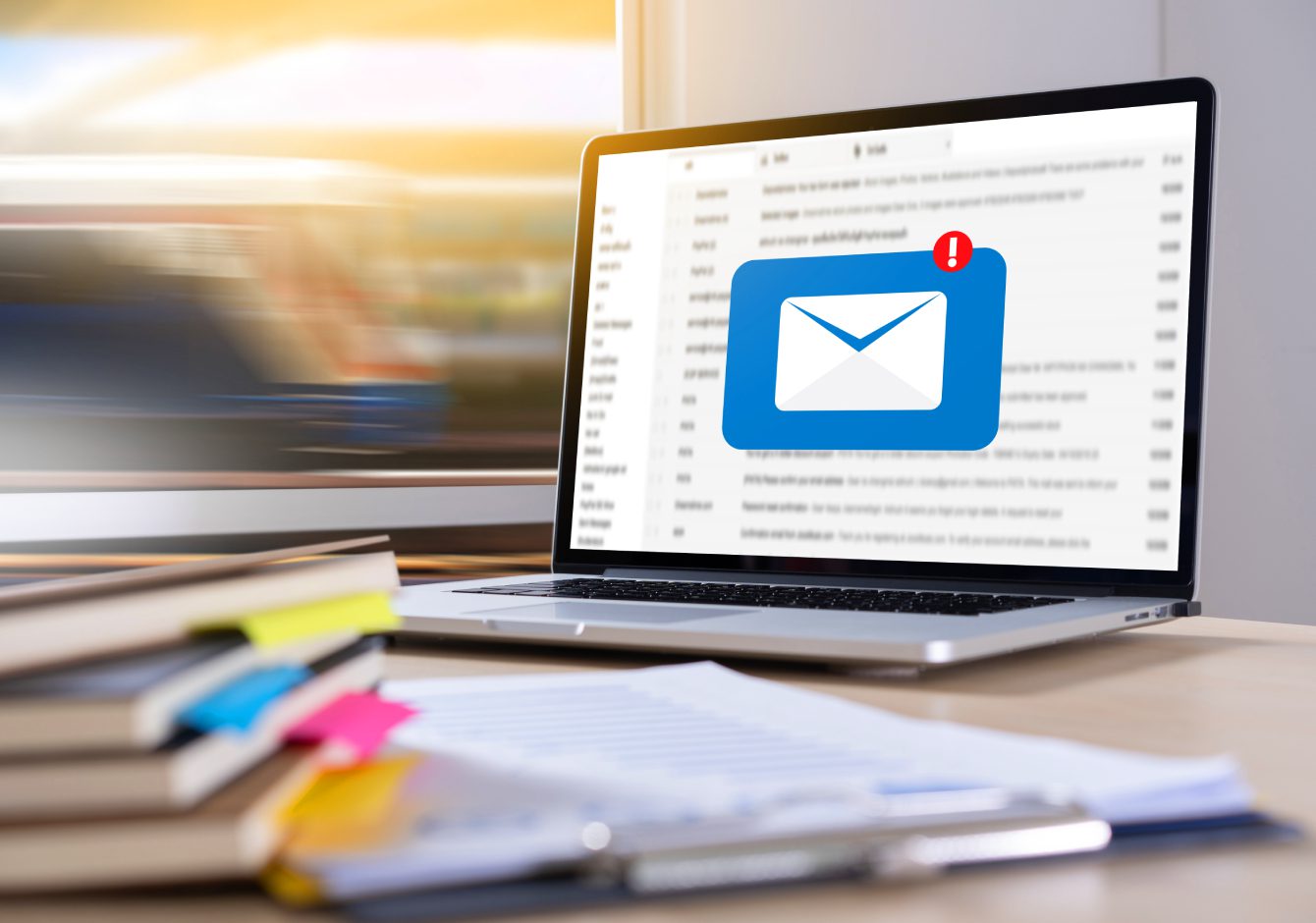 Laptop on desk with envelope inbox notification icon on screen