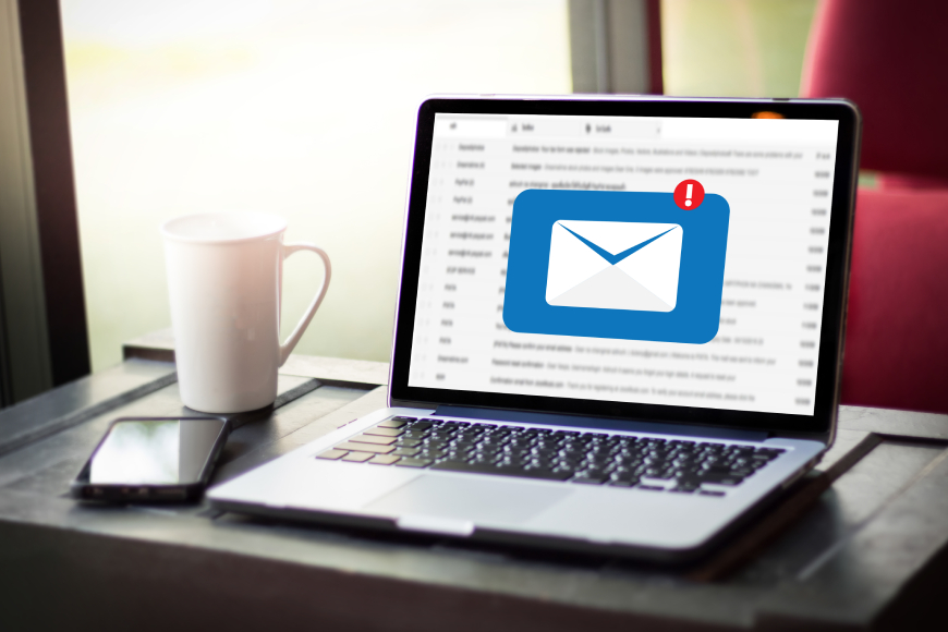 Laptop on desk with message envelope notification icon on screen